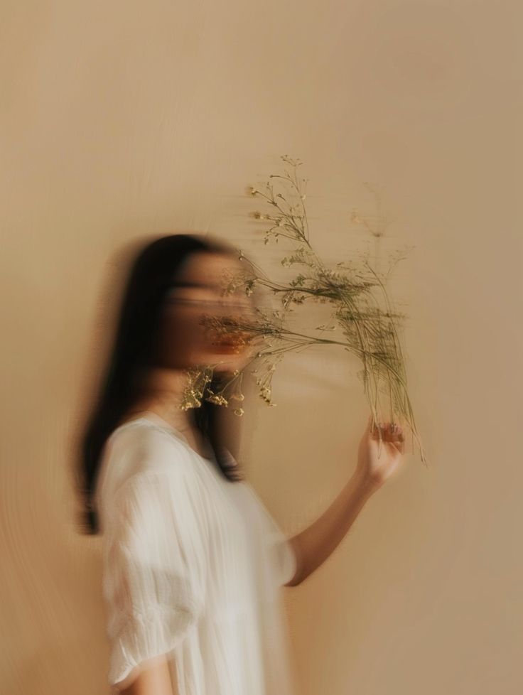 Mulher de vestido branco segurando um ramo de flores secas