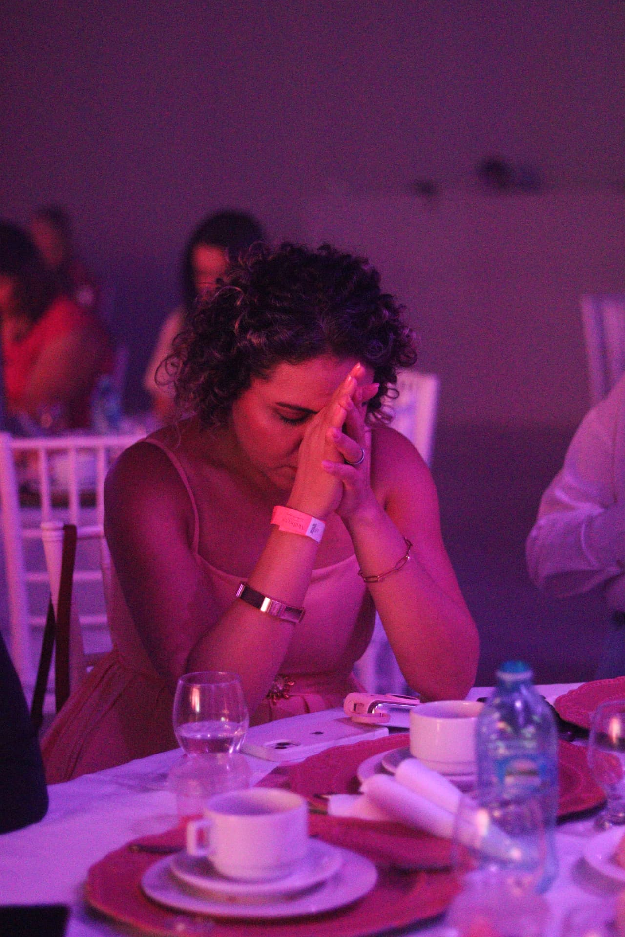 Participante em oração, à mesa, durante o encontro